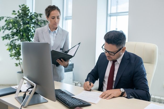 Accountants reviewing financial documents during self-assessment tax return preparation in an office setting
