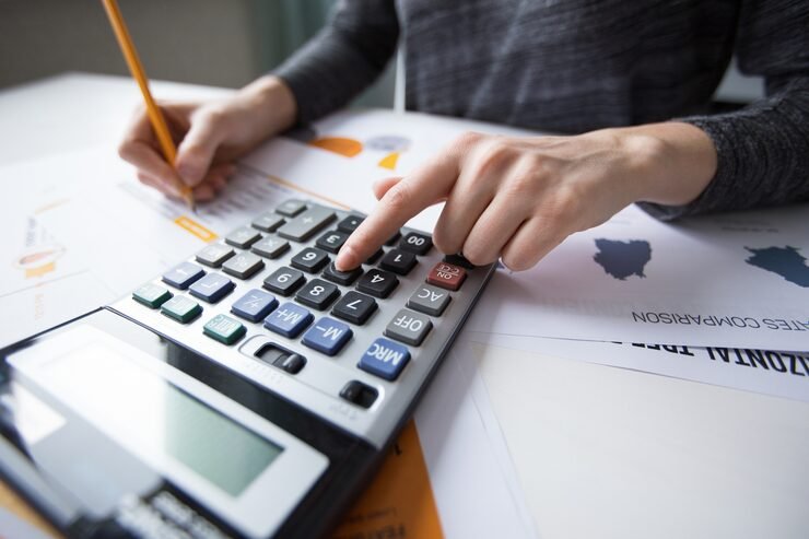 Female accountant using calculator for financial report