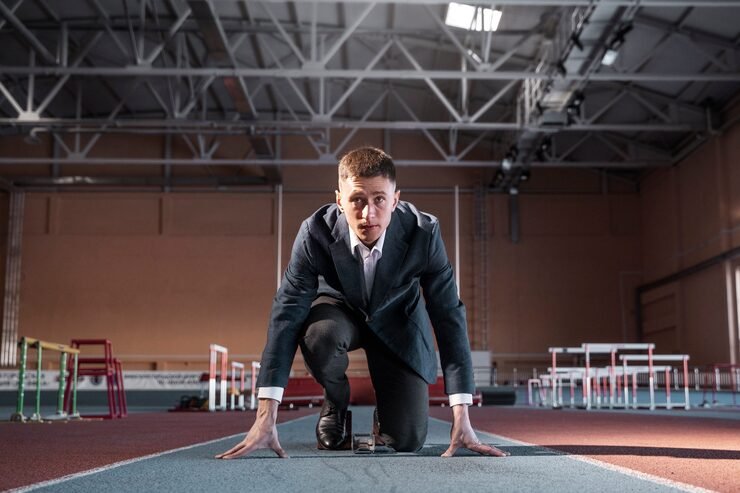 Businessman in suit ready to run towards financial goals