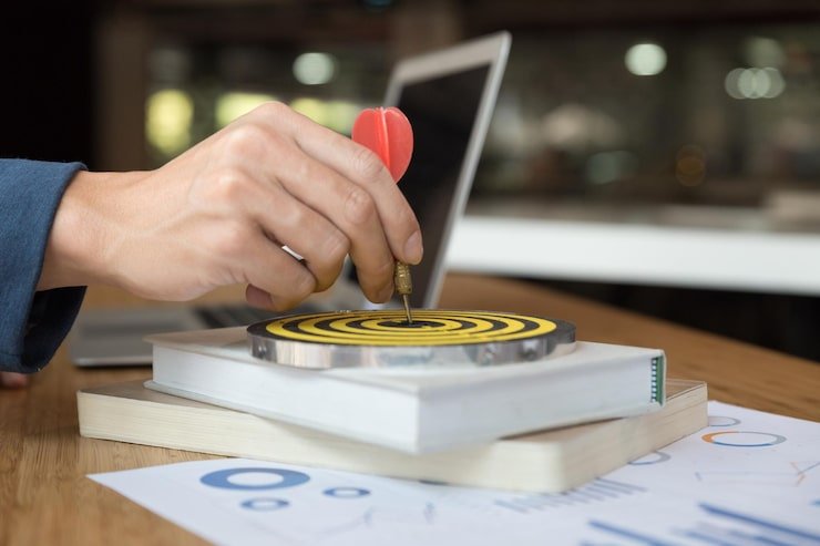 Person holding dart target symbolising business goals
