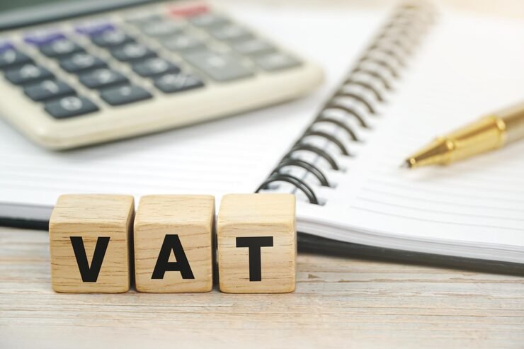 VAT concept with calculator, notebook and wooden blocks