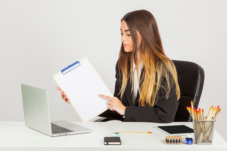 Professional businesswoman holding clipboard in office